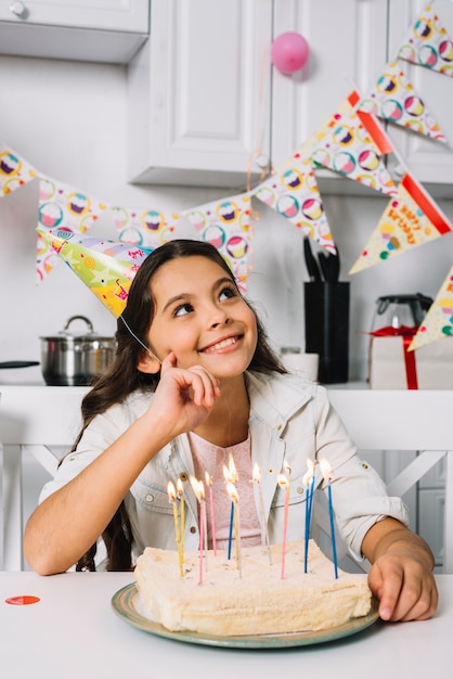 Sourire Jour Revant Fille Assise Devant Le Gateau D Anniversaire Avec Des Bougies Illuminees Photo Gratuite