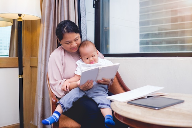 Sourire Mere Et Elle Mignon Peu Asiatique 18 Mois 1 An Enfant En Bas Age Bebe Garcon Enfant Livre Lecture Seance Chaise Chez Soi Photo Premium