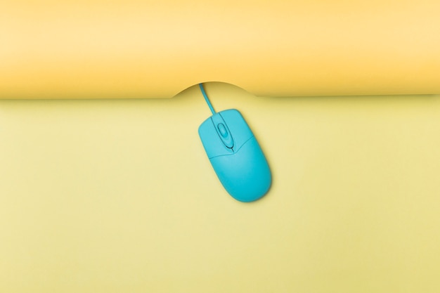 Souris d'ordinateur bleu vue de dessus avec fond jaune Photo gratuit