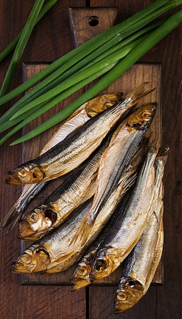 Sprat Fumé Et Oignon Vert Sur Une Planche à Découper. Poisson Fumé. Vue De Dessus Photo gratuit
