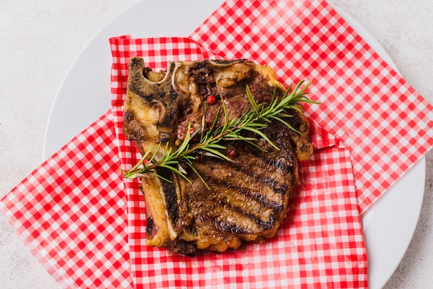 Steak sur assiette au romarin Photo gratuit