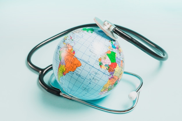 Stéthoscope sur le globe sur fond bleu Photo gratuit