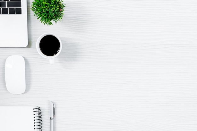 Table de bureau en bois blanc et équipement pour travailler avec un café noir dans la vue de dessus et le concept de ray plat. Photo Premium