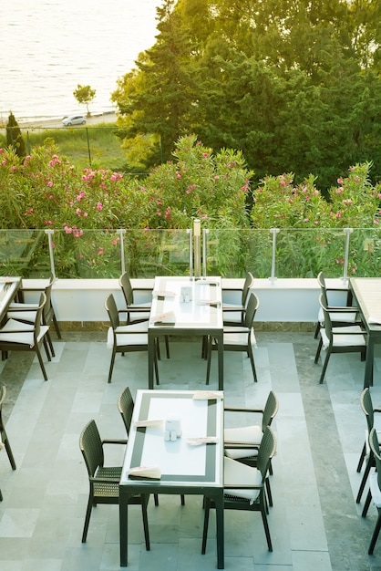 Une table en osier confortable dans le café-bar en plein air sur le toit le matin avec vue sur la mer, Photo Premium