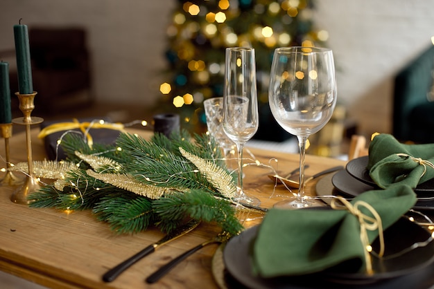 Table servie pour le dîner de noël dans le salon, vue rapprochée, réglage de la table, décoration de noël Photo Premium