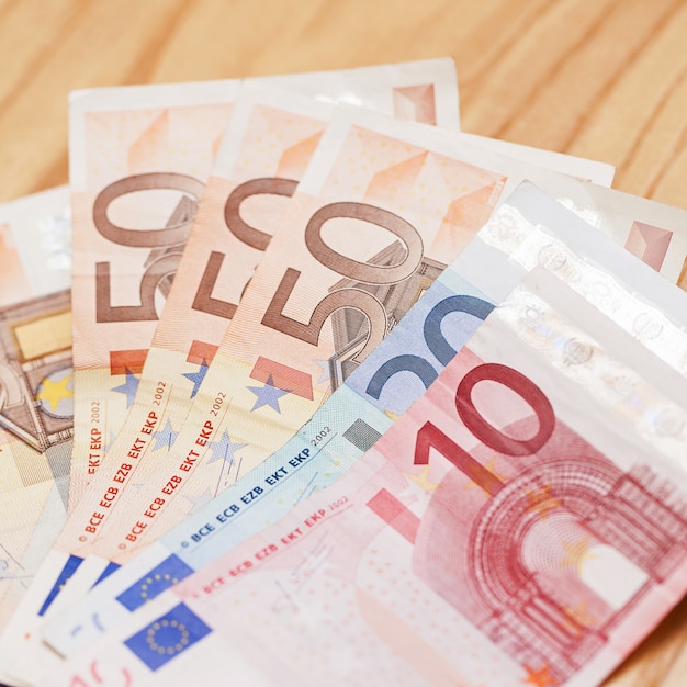 Tas de billets en euros sur une table en bois Photo gratuit