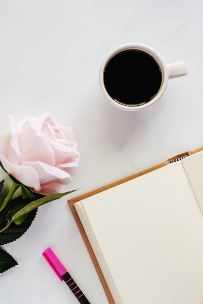 tasse-de-caf-noir-avec-un-cahier-ouvert-un-stylo-et-une-rose-rose