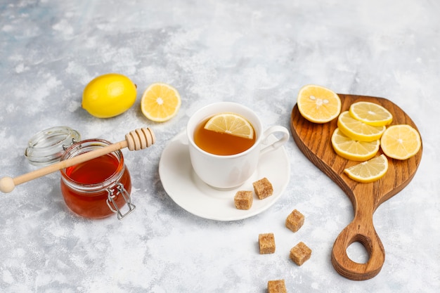 Une tasse de thé, de cassonade, de miel et de citron sur du béton. vue de dessus, espace de copie Photo gratuit