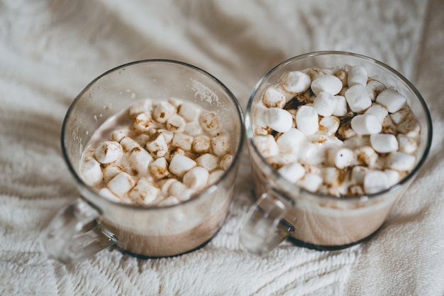 Tasses de cacao avec des guimauves près de la cheminée. Photo gratuit