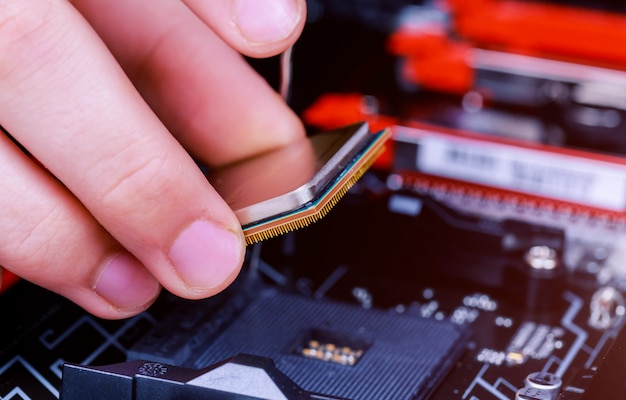Technicien en informatique installant le processeur dans la carte mère. fermer. Photo Premium