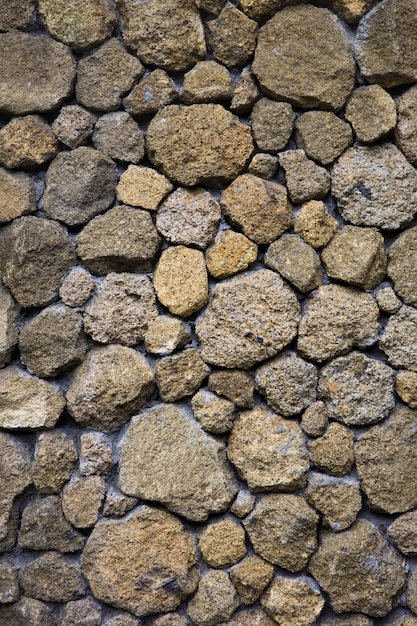 Texture d'un vieux mur de pierre à partir de différentes vieilles pierres inégales de différentes formes Photo Premium
