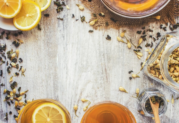 Thé vert au jasmin et noir avec citron transparent dans une petite tasse sur un fond clair. la théière mise au point sélective. Photo Premium