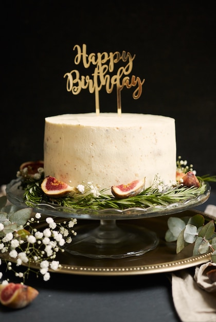 Tir Vertical D Un Gateau De Reve Blanc Joyeux Anniversaire Avec Des Feuilles Vertes En Bas Photo Gratuite