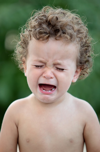 Triste Bebe Aux Cheveux Boucles Qui Pleure Photo Premium