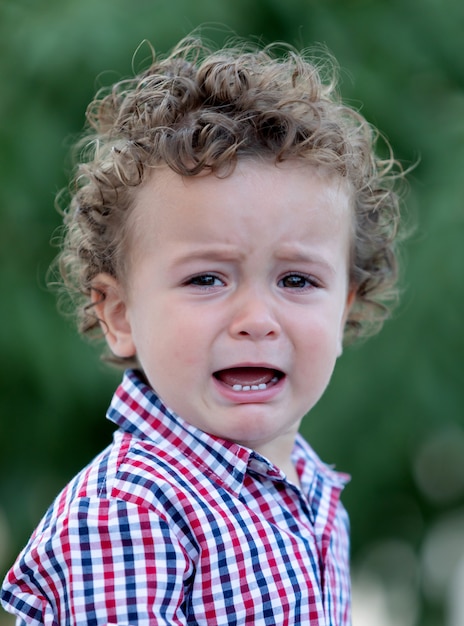 Triste Bebe Aux Cheveux Boucles Qui Pleure Photo Premium