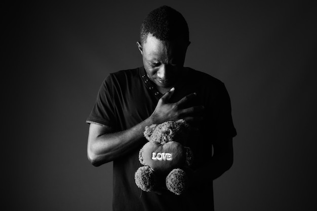 Triste Jeune Homme Africain Avec Ours En Peluche Et Texte De Signe D Amour En Noir Et Blanc Photo Premium