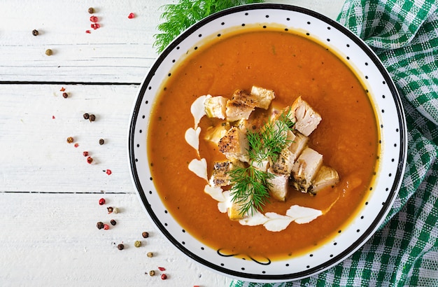 Velouté de potiron avec des morceaux de viande de poulet. la nourriture saine. dîner. vue de dessus. pose à plat Photo Premium