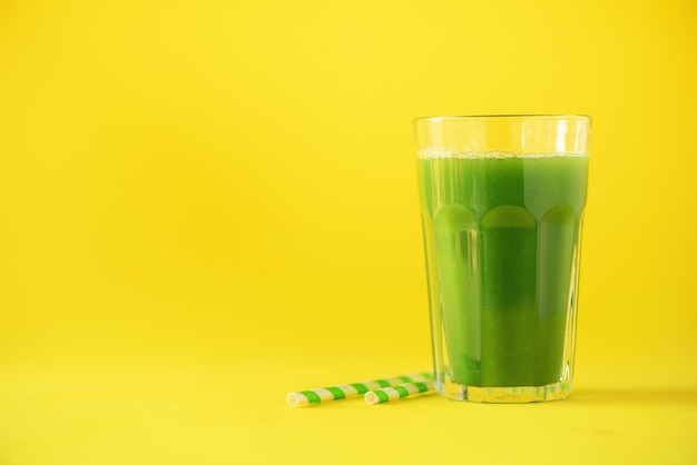 Verre de smoothie au céleri vert sur fond jaune Photo Premium