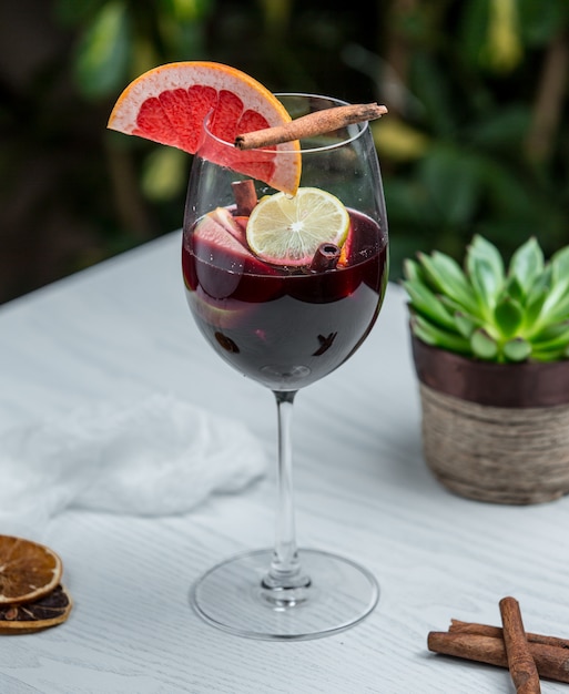Verre à vin avec pamplemousse à la cannelle et autres fruits Photo gratuit