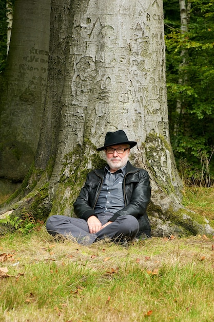 Vieil Homme Assis Sous Un Arbre Dans Le Parc Photo Premium