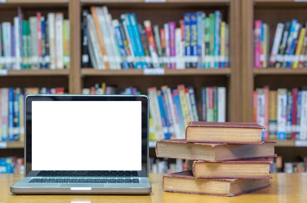 Vieux livre sur le bureau dans la bibliothèque avec tablette Photo Premium
