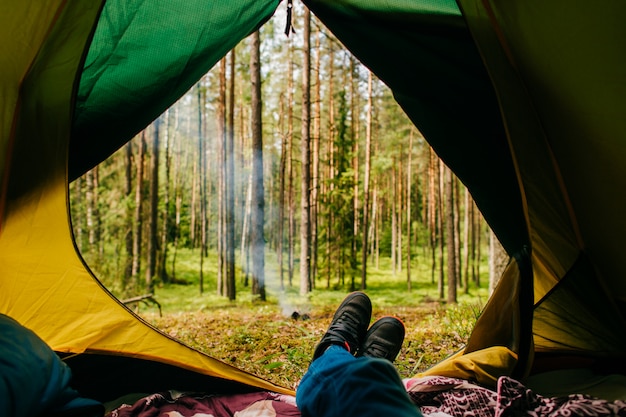Le voyageur profite d'une vue sur la nature depuis sa tente de camping. Photo Premium