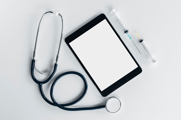 Une vue aérienne du stéthoscope; tablette numérique et seringue isolé sur fond blanc Photo gratuit