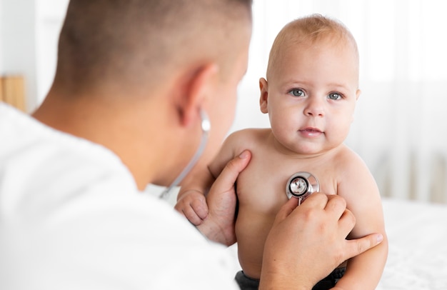 Vue Arriere Docteur Ecoute Petit Bebe A Stethoscope Photo Gratuite