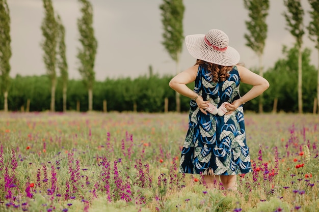 Vue Arriere D Une Maman Heureuse Tenant Ses Futures Chaussures De Bebe Debout Dans Un Champ Portant Un Chapeau Et Profitant Du Temps Chaud Photo Premium