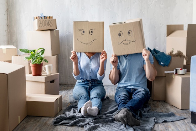 Vue Avant Du Couple Idiot Avec Des Boites Au Dessus De La Tete A La Maison Le Jour Du Demenagement Photo Gratuite