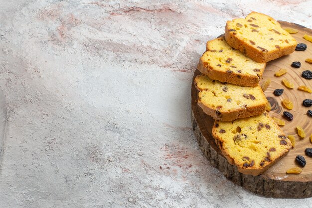 Vue Avant Du Gateau Aux Raisins Secs En Tranches Avec Des Raisins Secs Frais Sur Le Bureau Blanc Clair Photo Gratuite