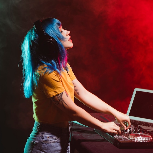 Vue de côté femme dj vivant la musique jouée Photo gratuit