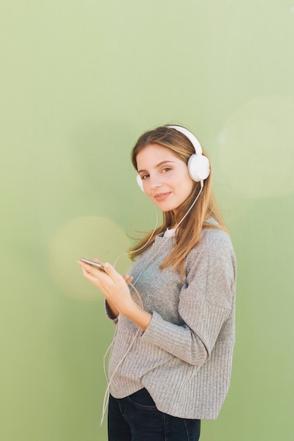 Vue Côté, De, A, Jeune Femme Souriante, écoute, Musique, Sur, Casque, Contre, Fond Vert Photo gratuit