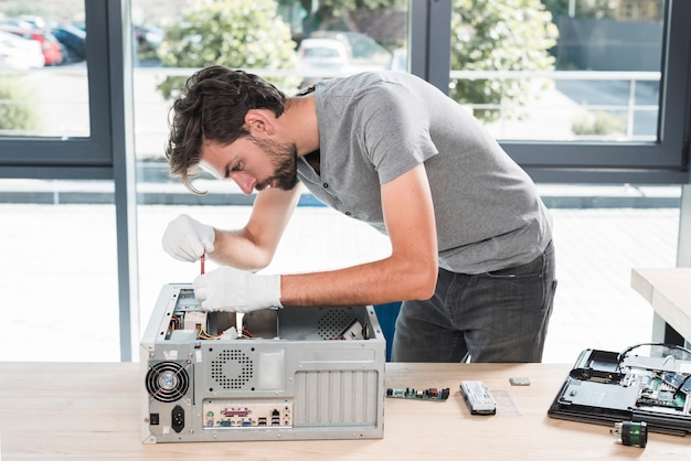 Vue côté, de, a, jeune technicien, réparation, ordinateur, dans, atelier Photo gratuit