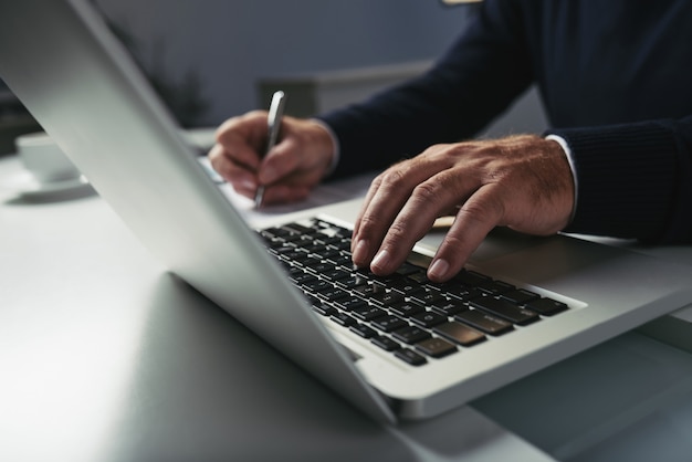 Vue côté, de, mains mâles, dactylographie, sur, clavier ordinateur portable Photo gratuit