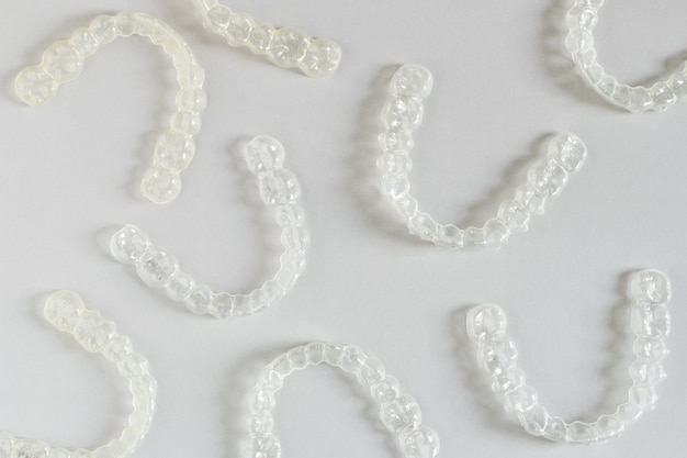 Vue de dessus des accolades invisalign ou des fixations invisibles sur fond gris Photo Premium