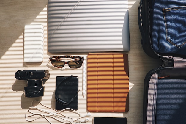 Vue de dessus d'appareils électroniques et d'une valise posée sur la table, prête pour un voyage d'affaires Photo gratuit