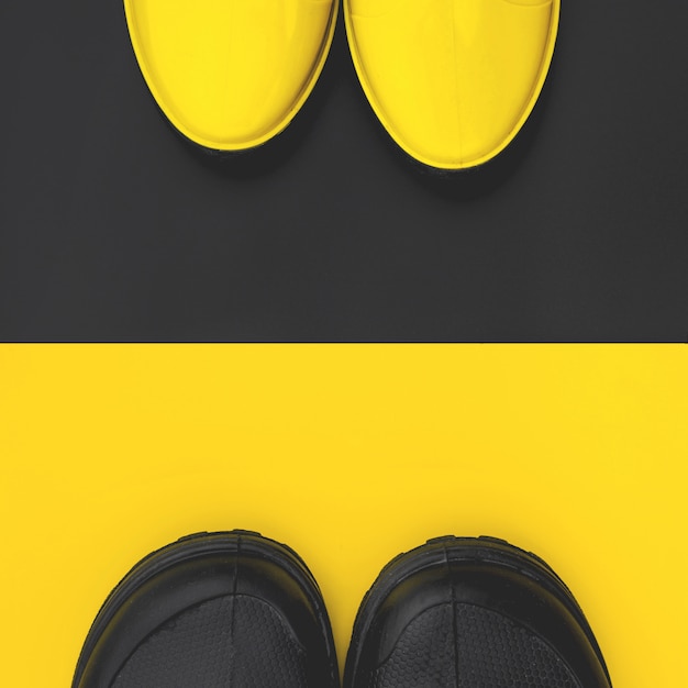 Vue de dessus de bottes en caoutchouc pour hommes et femmes à la mode sur des fonds contrastés. concept de l'automne et l'amour. copyspace. Photo Premium