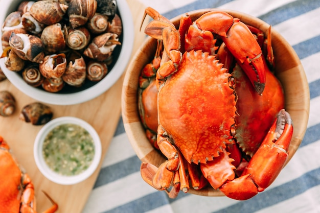 Vue de dessus des crabes de boue géants cuits à la vapeur dans un bol en bois servis avec une sauce thaïlandaise aux fruits de mer épicée. Photo Premium
