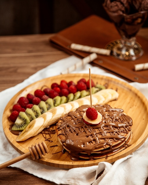 Vue De Dessus Des Crepes Au Chocolat Avec Kiwi Banane Et Fraises Sur Un Plateau Photo Gratuite