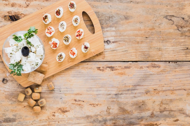 Une vue de dessus de cubes de fromage sur une planche à découper en bois Photo gratuit