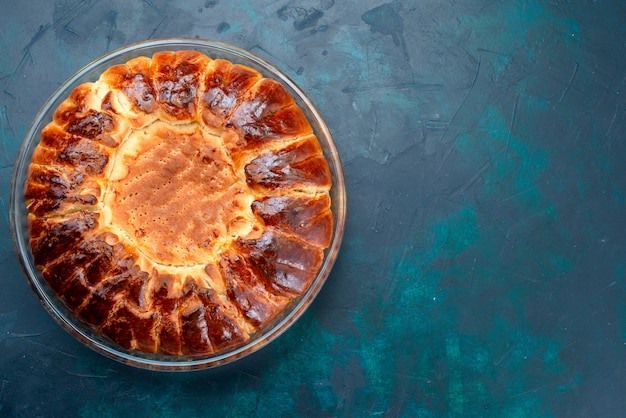 Vue De Dessus Un Delicieux Gateau Cuit Au Four Rond Forme A L Interieur D Une Casserole En Verre Sur Le Bureau Bleu Clair Photo Gratuite