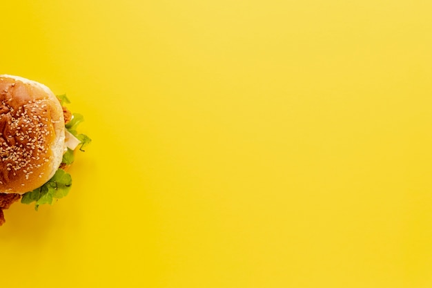 Vue de dessus avec demi-hamburger et fond jaune Photo gratuit