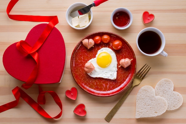 Vue de dessus du petit déjeuner romantique avec café et oeuf en forme de coeur Photo gratuit