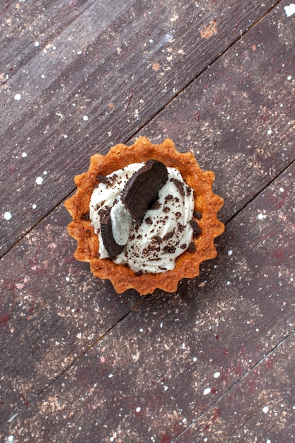 Vue De Dessus Du Petit Gateau A La Creme Et Au Chocolat Isole Sur Brun En Bois Gateau Biscuit Sweet Bake Photo Gratuite