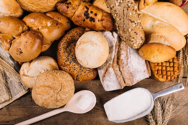 Une vue de dessus de la farine avec des pains de grains entiers cuits au four sur la table Photo gratuit