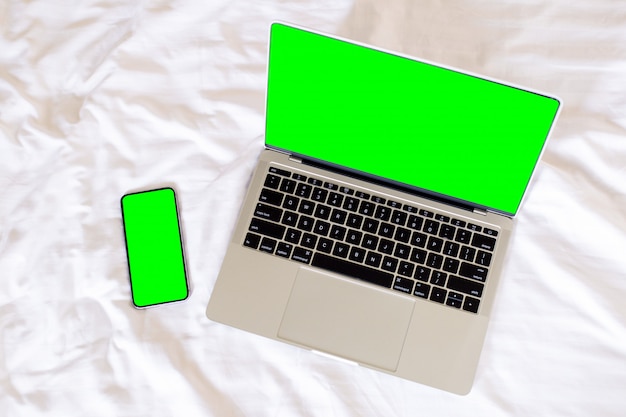 Vue de dessus ordinateur portable à écran vert vide et téléphone intelligent, Photo Premium