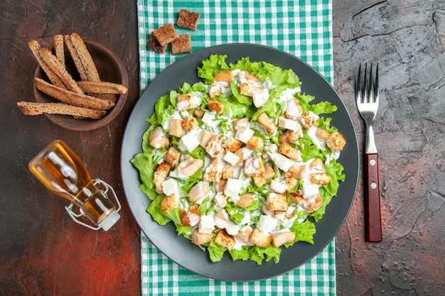 Vue De Dessus Salade César Sur Assiette Ovale Nappe à Carreaux Blanc Vert Fourchette Bouteille