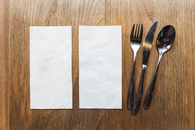 Vue de dessus des serviettes en tissu et des couverts sur la table en bois. pour bannière alimentaire. Photo Premium