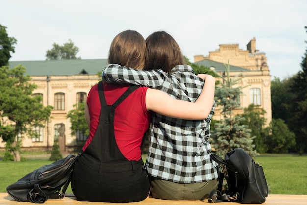 Vue de dos, moyen, de deux adolescentes embrassant Photo gratuit